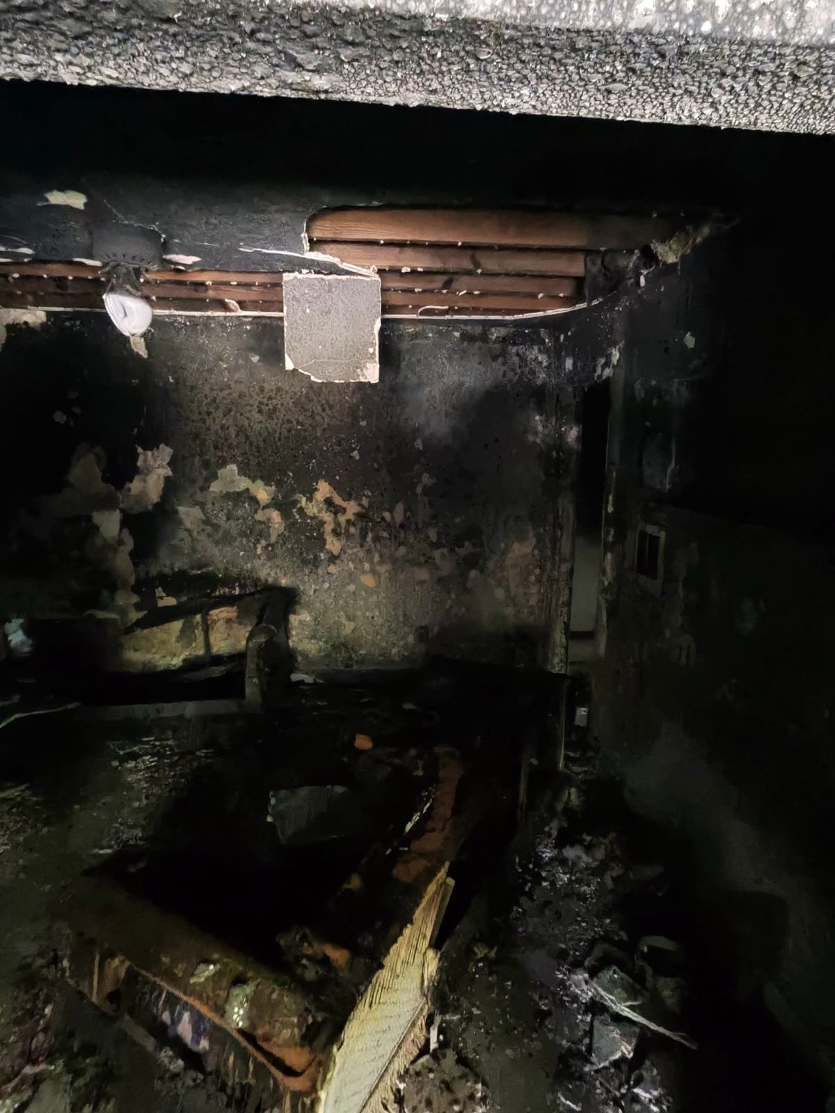 Charred framing and damaged interior walls in a fire-damaged house
