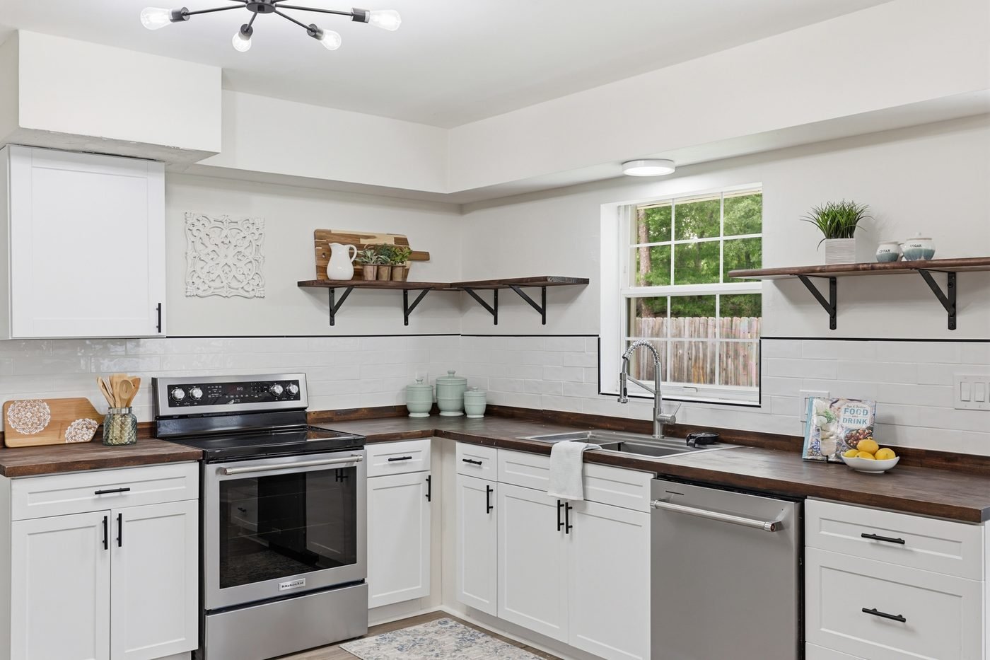 Renovated kitchen with white cabinets and butcher block counters